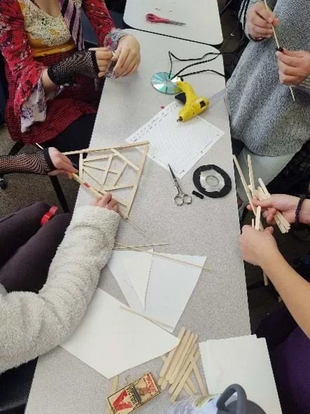Four students working together on the mousetrap car design challenge.