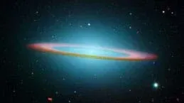 An infrared light image of Sombrero Galaxy. It looks like a large glowing bluish spot surrounded by a pinkish ring and many stars in endless dark space.
