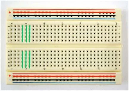 Photo shows a breadboard (circuit board) that has nothing connected to it. Colored lines are drawn over the breadboard to indicate which terminals are connected to each other.