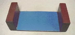 A photo shows two blocks placed on opposite ends of a bigger flat piece of wood.