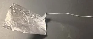 Una pieza de papel de aluminio cubre un alambre.