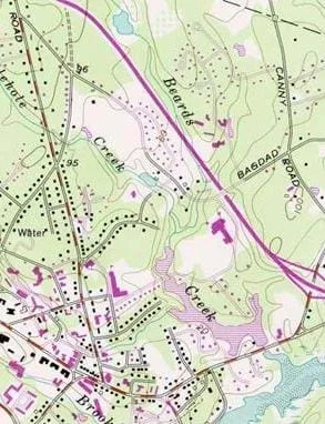 A topographic map showing many distinct features: lines, which represent elevation and colors, which indicate water (blue), tree cover (green) and no tree cover (white).