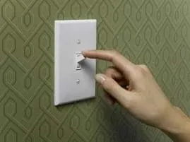 A finger pressing an on/off switch.