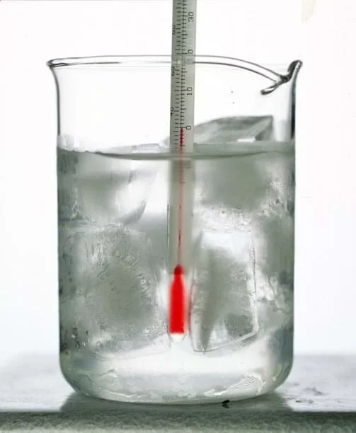 A photograph shows a thermometer immersed in ice water.