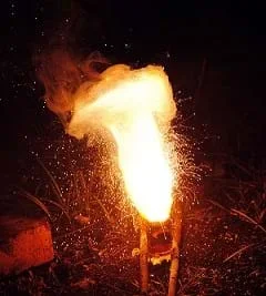 A photograph shows sparks flying off globules of molten iron, leaving smoke behind.