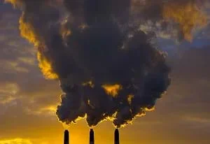 Air pollution released in the sky from three smokestacks.