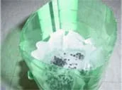 A photograph shows a 2-liter bottle with a standard coffee filter placed in the bottom half; the filter has begun to trap particles of carbon.