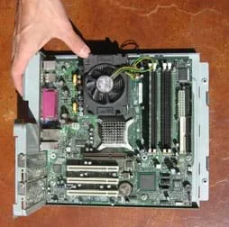 Photo shows complex arrangement of circuit boards, integrated circuits, pins, wires, chips and fan pulled from inside a PC.