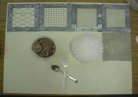 A photograph showing the activity "filters." From left to right are different-sized screening with large holes to small holes. Also shown is poultry netting, a coffee filter, a container of pebbles and a fork and spoon.