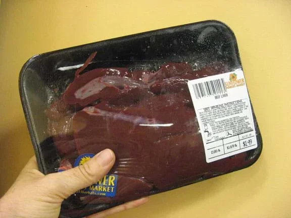 Photo shows reddish-brown meat wrapped in plastic wrap.