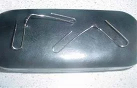 A photo shows two bent paperclips with the two curved ends pulled away from each other at right angles.