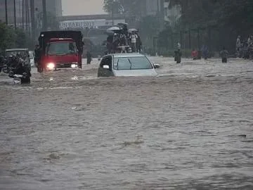 Cars and people amidst the flooded streets of Jakarta in Indonesia on January 17, 2013.