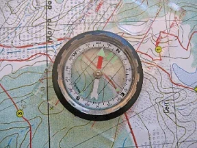 A compass resting on top of a map.