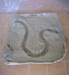 Photo shows a pan of clay with a meandering ditch cut into it.