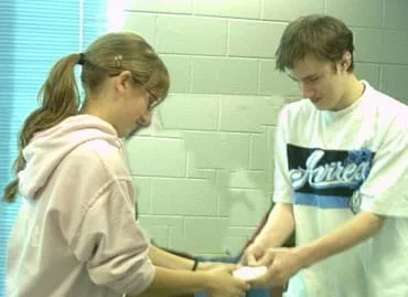 Photo of two students, each pulling on one end of a bar of soap.