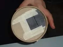 The index card pieces have been taped to the bottom of the container with a gap between them.