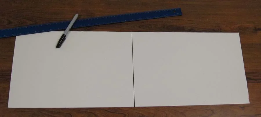 Photo shows a black line equally splitting a rectangular piece of white paper.