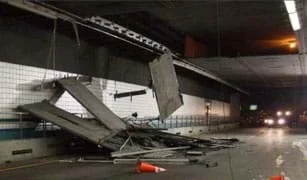 Photo inside a tunnel shows concrete panels dangling from the ceiling and piled on the ground on top of a crushed car.