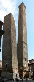 Una fotografía muestra las "torres gemelas" de Bolonia, Italia-torres de masonería una junto a la otra, ~150 pies de altura y 300 pies de altura respectivamente, ambas con bases mas anchas que sus partes superiores. La más baja en primer plano se inclina un poco.