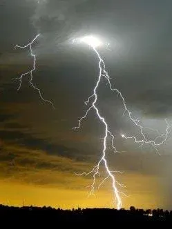 Photo shows a dark sky with a bright and jagged lightning bolt.