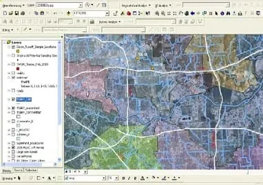 An image from ESRI's ArcGIS® software with a table of contents on the left that gives layers that can be turned on and off, a top screen space that has many different icons for GIS manipulation tools, and a main screen on the right and center that displays aerial photos and GIS layers on top of them.