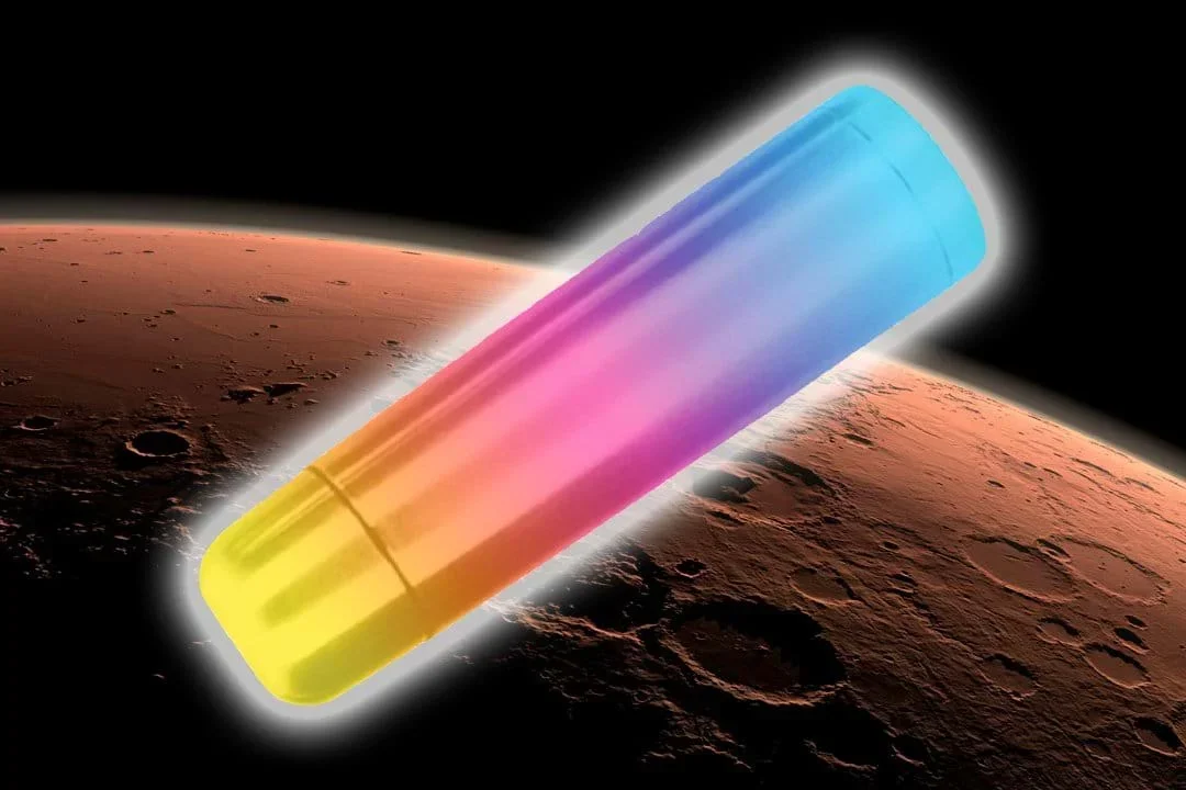 A digitally edited image showing a colorful thermos floating above the surface of Mars. The thermos is elongated and cylindrical, with a gradient of colors transitioning from yellow at the bottom, through pink and purple in the middle, to blue at the top. The planet Mars is shown below, and the background is black space.