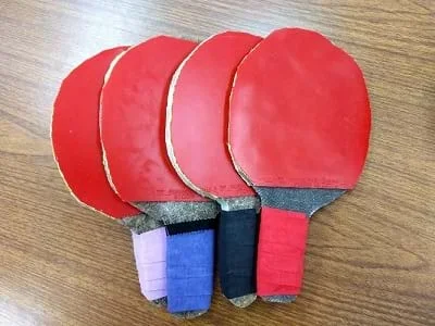 Four biocomposite ping-pong paddle prototypes lay on a table.