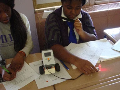 Photograph of students recording data and plotting values to determine the concentrations of unknown solutions.