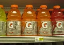 Photo shows five 32-ounce (846 ml) jugs of yellow, orange and red Gatorade sports drink on a grocery shelf.