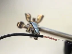 A photograph shows a stripped wire held by a clamp, showing exposed copper as well as insulating material with the non-insulated nichrome wire wrapped around the exposed copper wire.