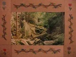 Photo shows a woodland scene framed by a decorative frame.