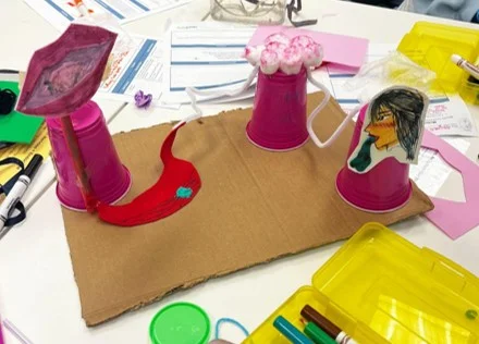 A photo showing a three-dimensional student model made with cups, drawings, and craft materials to represent organs and system interactions.