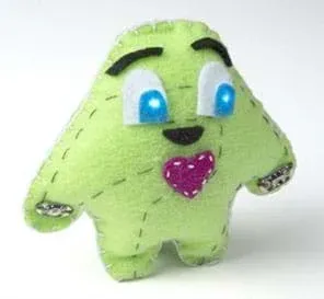 A photograph shows a plump, blob-shaped “plush” toy creature with loosely shaped arms and legs, light-up cartoon eyes (from sewn-in circuit with LEDs), eyebrows and a red heart made of stitched green felt.