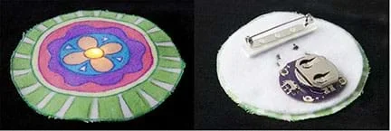 A photograph shows the front and back of a completed, three-inch circle-shaped pin. On the left, the front, a LED light shines through the center of a colorful flower design on white fabric. On the right, the finished back of the pin shows a disc battery in its holder, conductive thread tracers, and a safety pin-type fastener for clothing attachment.