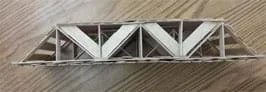 A photograph shows the side view of a section of two-layer roadway made with flat wooden sticks with rounded ends laid side by side. The middle support section between the two layers is composed of vertical and angled wooden pieces of different widths and lengths that form a triangular truss structure.