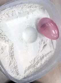 A photograph shows a plastic tub filled with flour (fine white powder) into which a round indentation (concave) has been made, like a moon crater. Nearby sits an egg-shaped plastic shell, which caused the indentation when it was dropped into the flour from above.