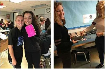 Left: two female students stand and display their pink shin guard prototype.
Right: two female students stand at a counter attaching elastic straps to their shin guard prototype.
