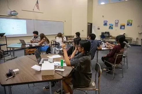 A photo showing a teacher demonstrating the experimental protocol to the students in the classroom.