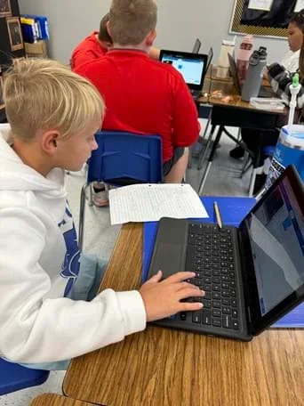 A photo showing a student using their custom code to code the micro:bit.