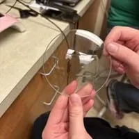 A photo showing a student holding a piece of round glass substrate.