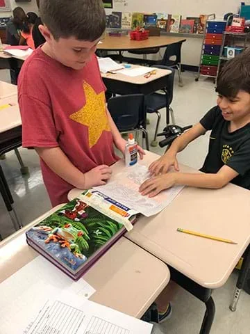 Two students working on their designs.
