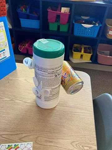 An invention created from a cylinder-shaped plastic wipes container with clear water bottle lids glues to one side and a metal water can be taped to the other.