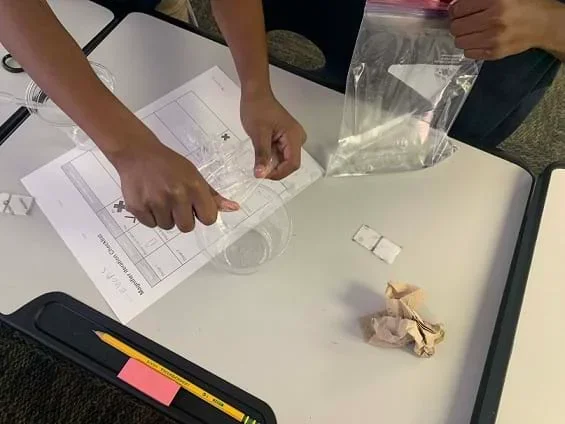 A part of students work on their design, made up of a plastic bag filled with water for refraction.
