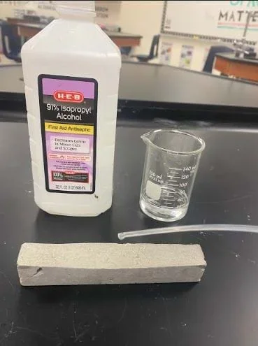 The image shows the drop test station. This station tests for wettability of the concrete sample and the reactivity of the concrete sample to water, soap, and alcohol. Droppers are used to drop one drop of each liquid being tested at a time. Wettability is tested by recording the water being dropped and timing how long it takes for the water to absorb into the sample.