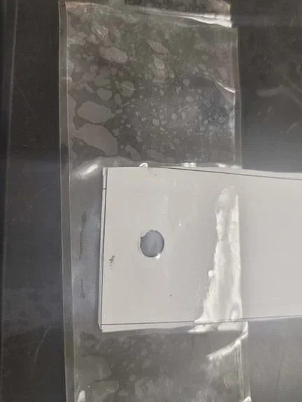 Photo of the top part of a paper strip with a hole punched in it that is reinforced with tape.