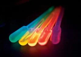 Photo shows five glowing colored vials: blue, yellow, orange, red, violet.
Source/Rights: ANL, OSTI Blog, US