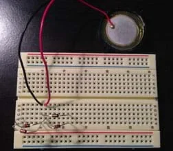 The same breadboard as Figure 2, now with a two-wire piezo element connected with black and red wires