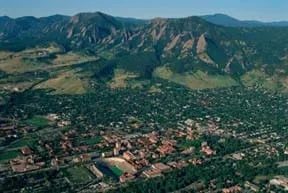 Aerial photo shows a city layout surrounded by open space, with mountains in the background