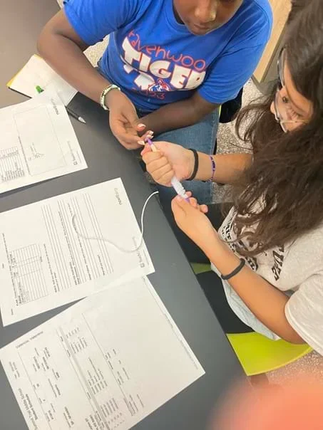 A photo showing students designing and building their device.