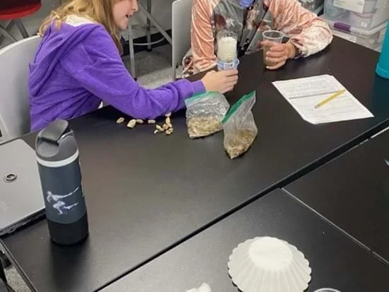 A photo showing students building water filtration systems.